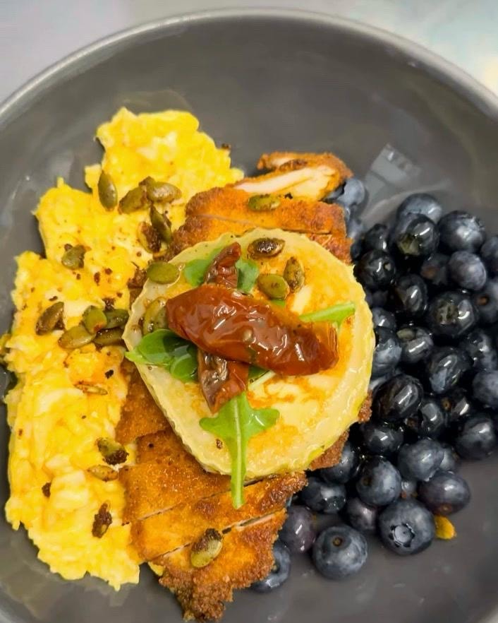 Breaded chicken with scrambled eggs, halloumi, pumpkin seeds and blueberries